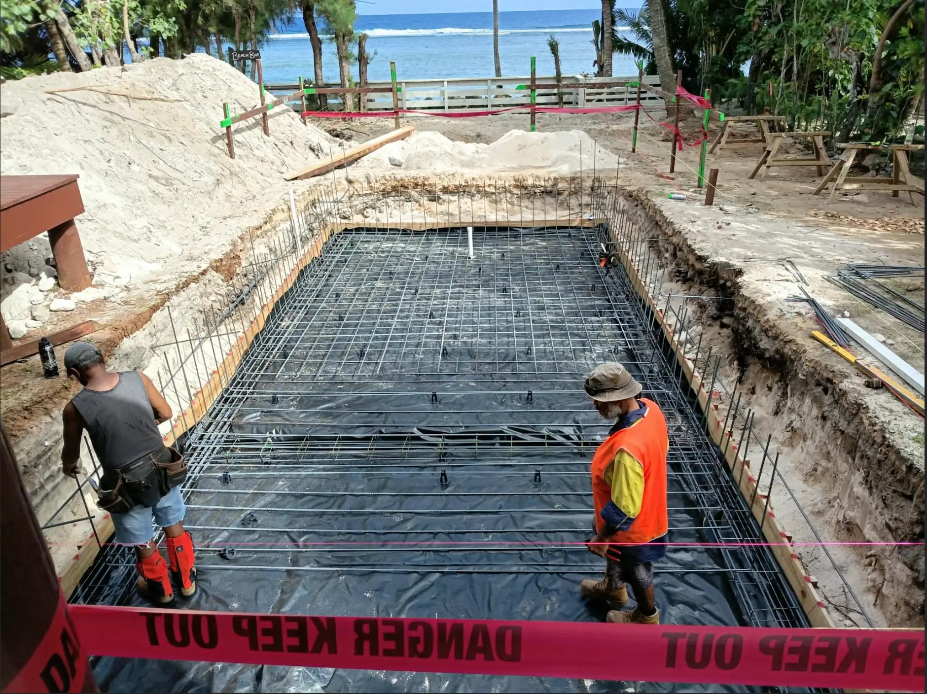 Steel reinforcement being laid for a concrete pool by the beach